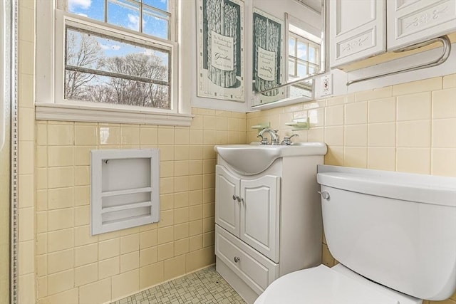 half bathroom featuring tile walls, toilet, and vanity