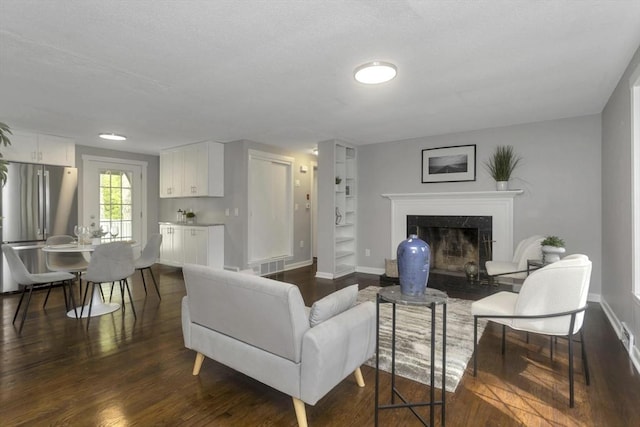 living area with dark wood finished floors, a fireplace, and baseboards