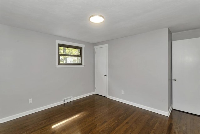 empty room featuring wood finished floors and baseboards