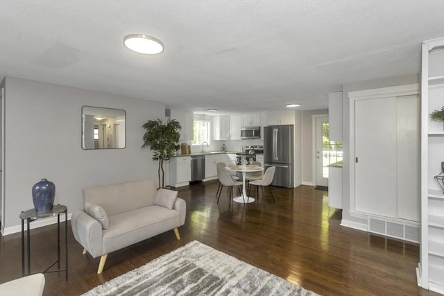 living room with dark wood-type flooring and baseboards