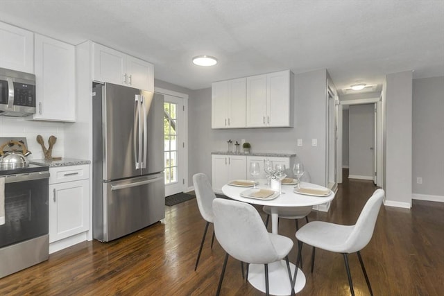 dining area with dark wood-type flooring and baseboards