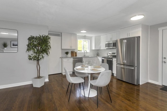dining space featuring baseboards and dark wood finished floors