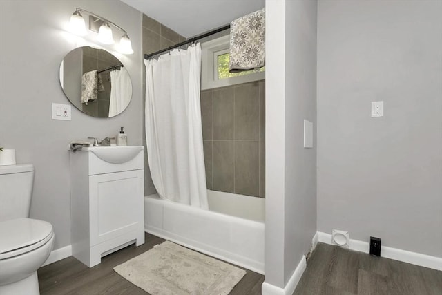 bathroom with toilet, wood finished floors, baseboards, and shower / tub combo with curtain
