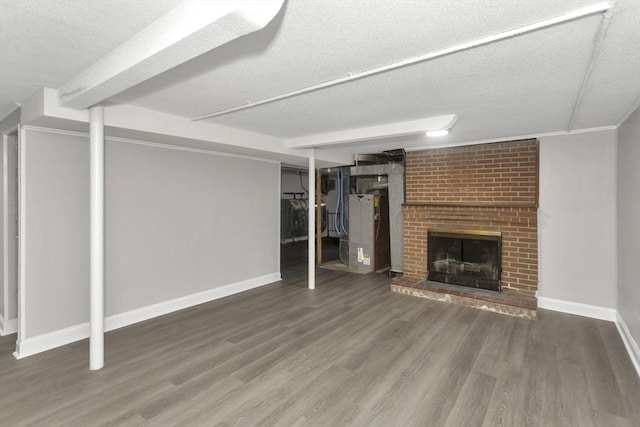 unfurnished living room with a textured ceiling, wood finished floors, baseboards, and a fireplace