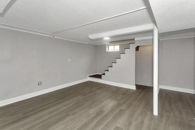 basement with stairs, wood finished floors, baseboards, and a textured ceiling