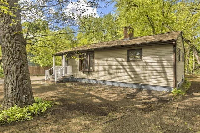 view of side of property with a chimney and fence