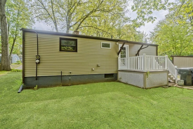 back of house with a deck and a lawn