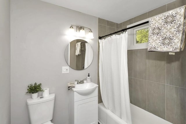 bathroom featuring toilet, shower / bath combo, and vanity