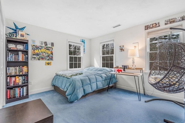 carpeted bedroom featuring baseboards and multiple windows