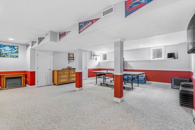 game room featuring visible vents, carpet floors, a glass covered fireplace, and a healthy amount of sunlight