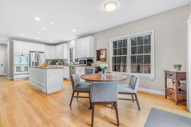 dining room featuring recessed lighting, beverage cooler, baseboards, and light wood-type flooring