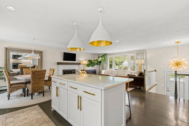 40 Brewster Rd, Cohasset, MA 02025 - kitchen with a glass covered fireplace, white cabinets, open floor plan, dark wood-style flooring, and recessed lighting