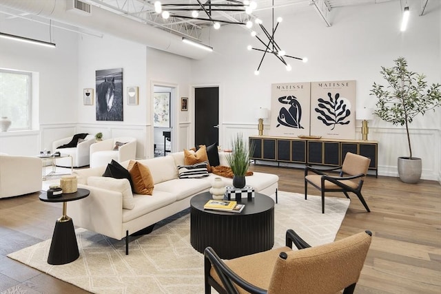 living room featuring an inviting chandelier, a towering ceiling, and hardwood / wood-style flooring