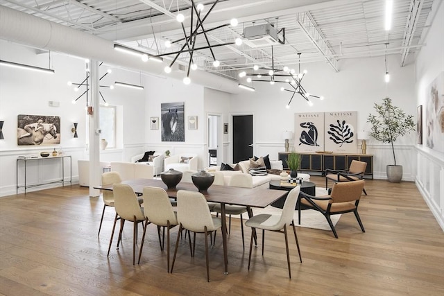 dining space featuring hardwood / wood-style floors and a high ceiling