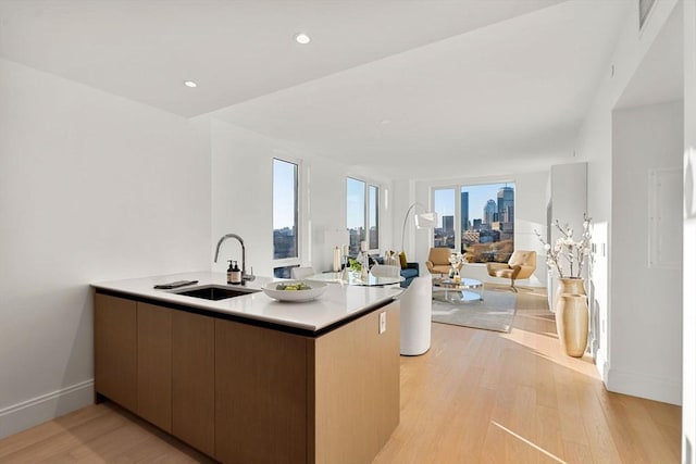 kitchen with sink, light hardwood / wood-style floors, and kitchen peninsula