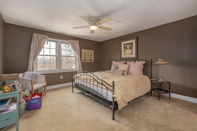 carpeted bedroom with visible vents, a ceiling fan, and baseboards