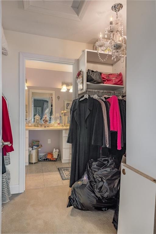 walk in closet with carpet flooring and an inviting chandelier