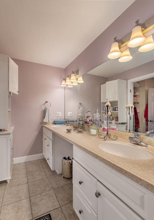 bathroom with tile patterned flooring, baseboards, and vanity