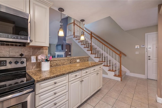 kitchen with light tile patterned flooring, stainless steel appliances, baseboards, light stone countertops, and tasteful backsplash