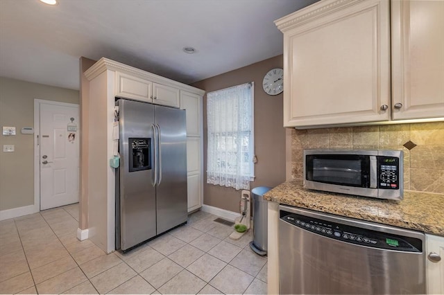 kitchen with light tile patterned floors, stainless steel appliances, visible vents, backsplash, and light stone countertops