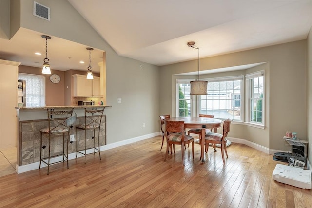 dining room with lofted ceiling, recessed lighting, visible vents, light wood-style floors, and baseboards