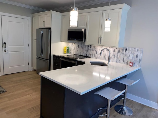 21 Totman St Unit 306, Quincy, MA 02169 - kitchen featuring appliances with stainless steel finishes, light countertops, decorative backsplash, and ornamental molding