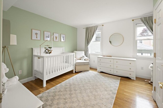 4 Lincoln Pl Unit 4, Boston, MA 02129 - bedroom with multiple windows, light wood-type flooring, a crib, and baseboards