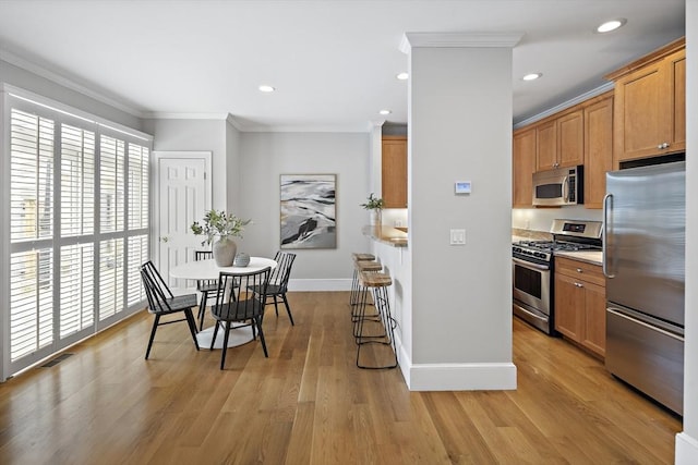 4 Lincoln Pl Unit 4, Boston, MA 02129 - kitchen with appliances with stainless steel finishes, crown molding, light countertops, baseboards, and light wood finished floors