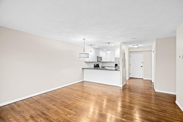 41 Centre Unit 208, Brookline, MA 02446 - unfurnished living room with baseboards, wood finished floors, and a sink