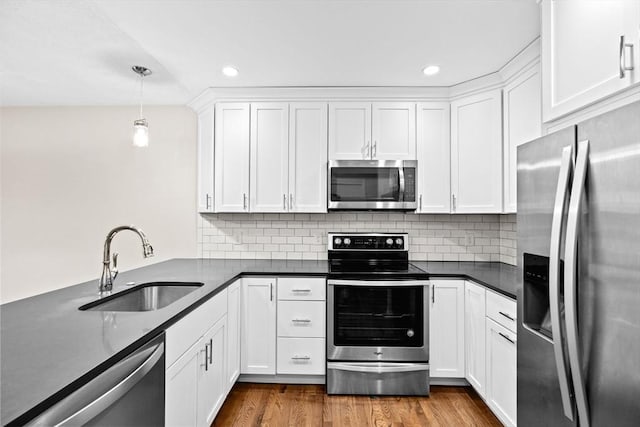 41 Centre Unit 208, Brookline, MA 02446 - kitchen with appliances with stainless steel finishes, a sink, dark countertops, white cabinets, and recessed lighting