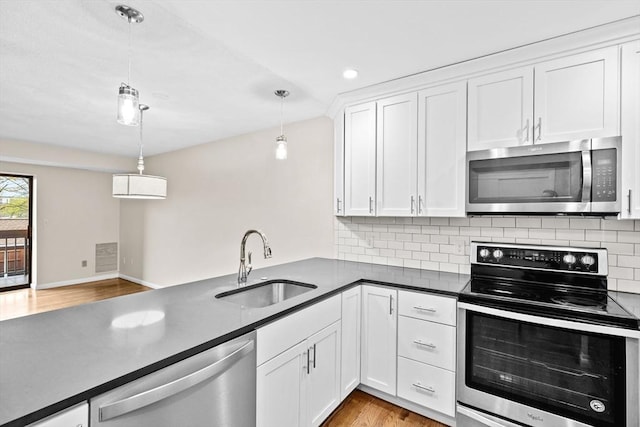41 Centre Unit 208, Brookline, MA 02446 - kitchen with appliances with stainless steel finishes, a sink, dark countertops, decorative backsplash, and recessed lighting