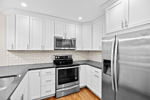 41 Centre Unit 208, Brookline, MA 02446 - kitchen with stainless steel appliances, white cabinetry, decorative backsplash, recessed lighting, and dark countertops