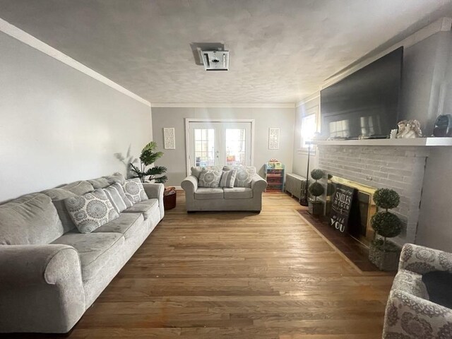 98-100 Fenwick St, Springfield, MA 01109 - living area with wood finished floors, a brick fireplace, crown molding, and radiator heating unit