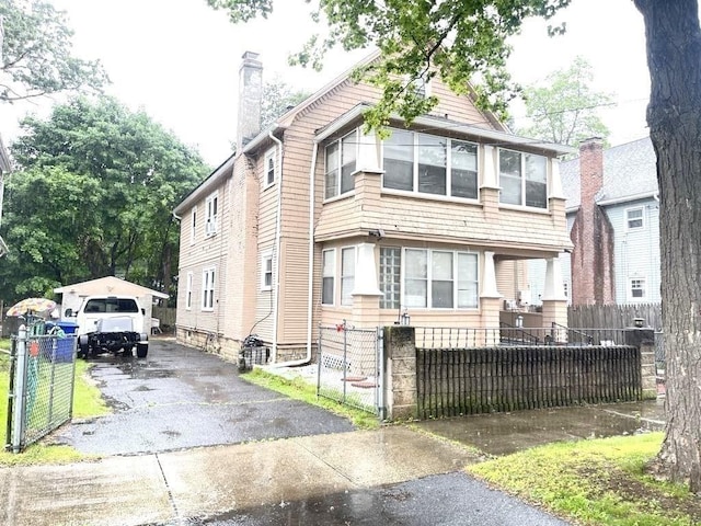 98-100 Fenwick St, Springfield, MA 01109 - view of front facade featuring a chimney, a detached garage, an outbuilding, and driveway