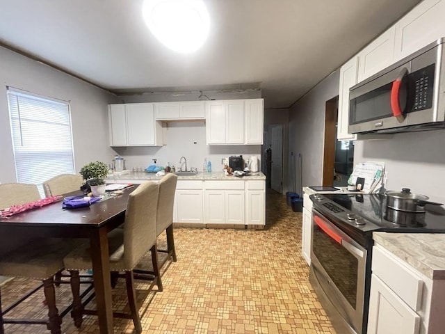98-100 Fenwick St, Springfield, MA 01109 - kitchen featuring stainless steel appliances, light countertops, white cabinetry, and light flooring