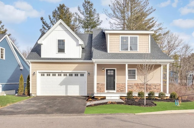 view of front of home with aphalt driveway, a porch, stone siding, and roof with shingles