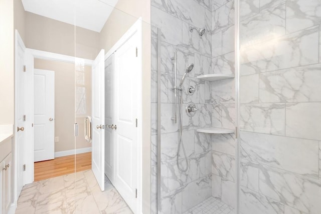 full bathroom with baseboards, vanity, marble finish floor, and a shower stall