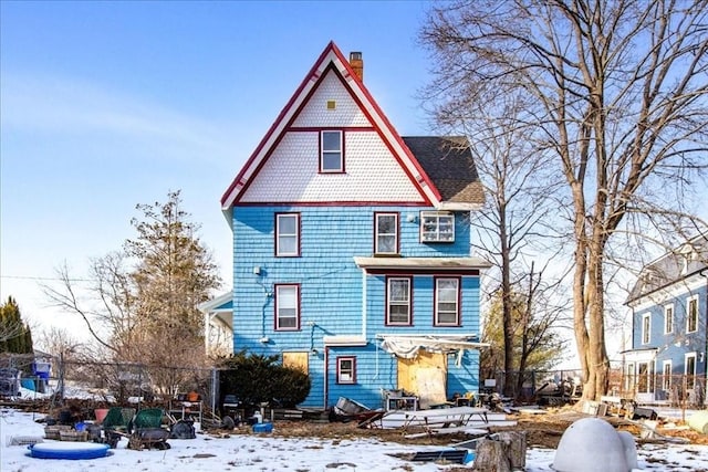 victorian home featuring a chimney and fence