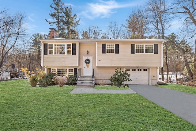 bi-level home featuring a garage and a front lawn