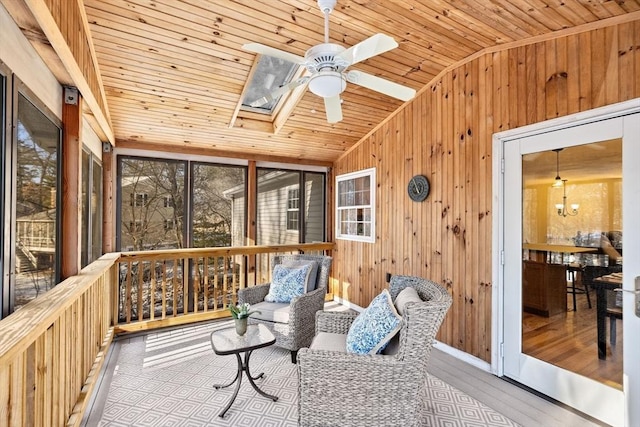 sunroom with ceiling fan, lofted ceiling with skylight, and wooden ceiling