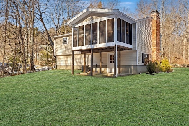 back of property featuring central AC unit, a lawn, and a sunroom