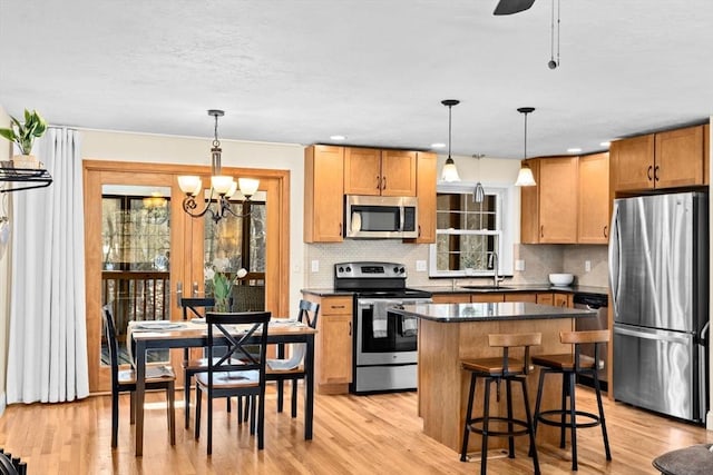 kitchen featuring decorative light fixtures, sink, a wealth of natural light, and appliances with stainless steel finishes