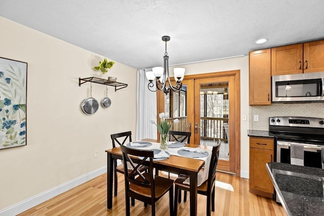 dining room featuring light wood-type flooring and an inviting chandelier