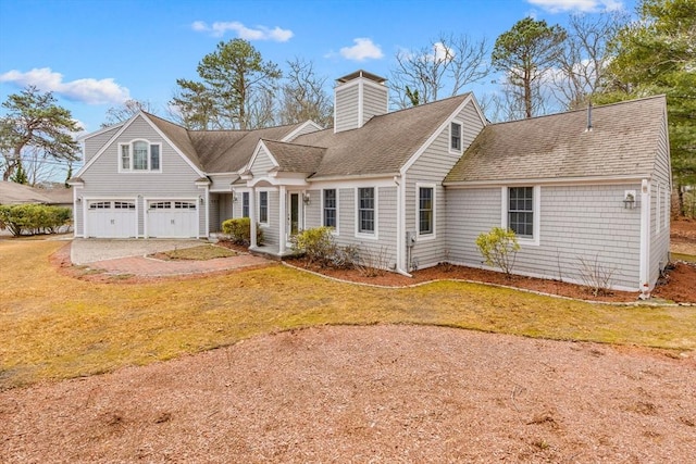 new england style home featuring a garage and a front lawn