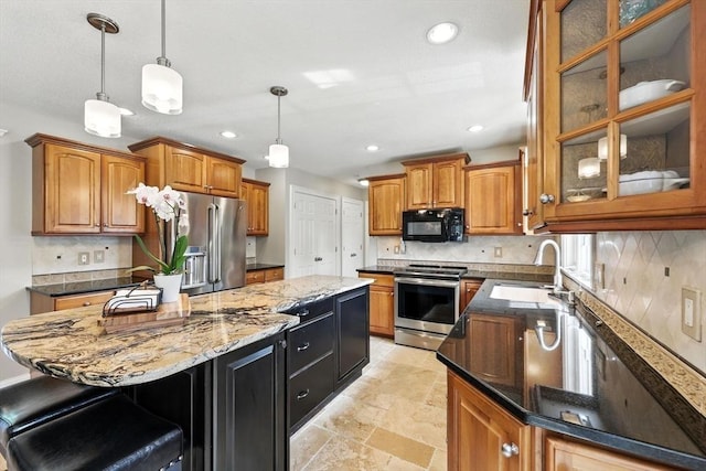 11 Rachael Ter, Westfield, MA 01085 - kitchen featuring appliances with stainless steel finishes, a center island, brown cabinetry, dark stone countertops, and recessed lighting