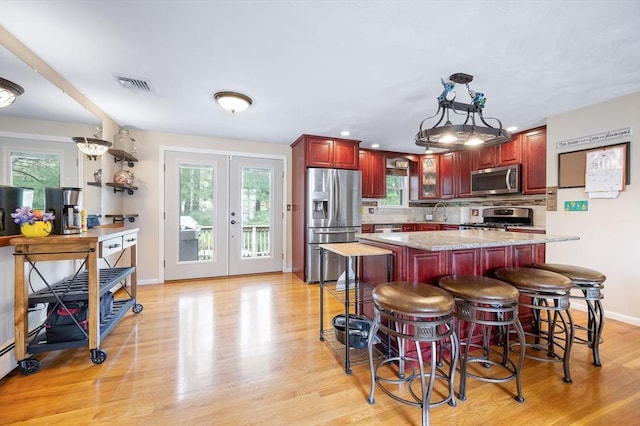 kitchen featuring stainless steel appliances, dark brown cabinets, backsplash, plenty of natural light, and recessed lighting