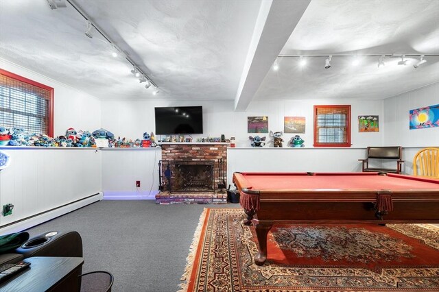 game room with rail lighting, a baseboard radiator, a fireplace, carpet, and wainscoting