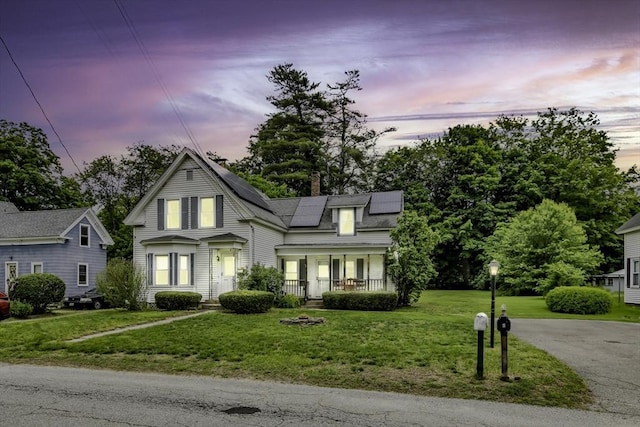 5 Bow St, Townsend, MA 01469 - view of front of home with a yard, roof mounted solar panels, a porch, and a chimney