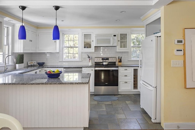 8 School House Vlg, Oak Bluffs, MA 02557 - kitchen with stainless steel appliances, a sink, decorative backsplash, white cabinetry, and crown molding