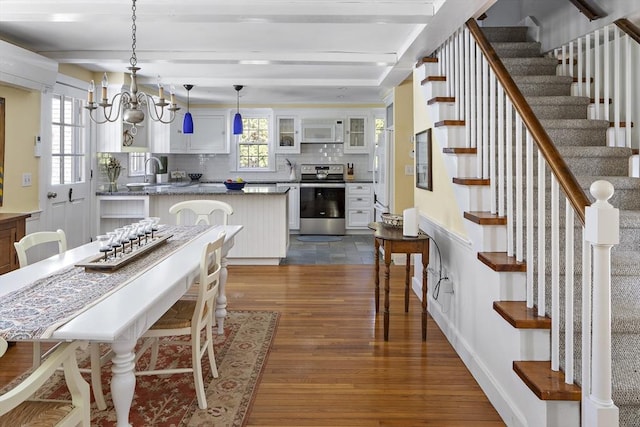 8 School House Vlg, Oak Bluffs, MA 02557 - dining room featuring dark wood finished floors, stairway, and a chandelier